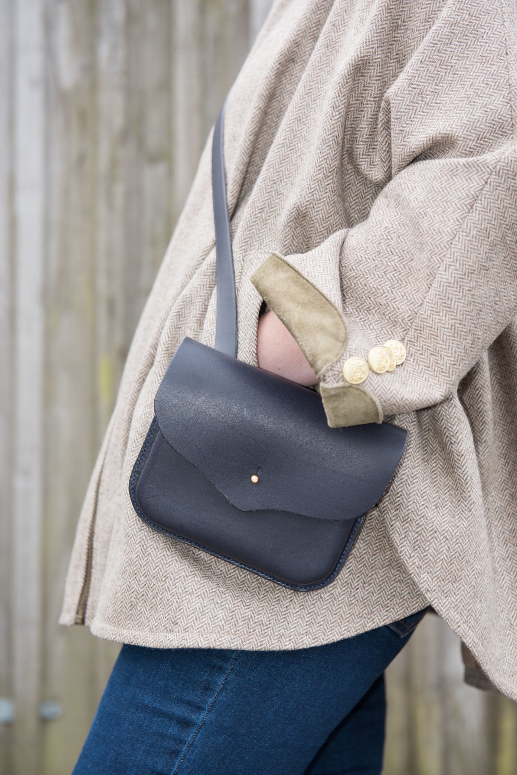 Picture of a woman's torso wearing a crossbody handbag